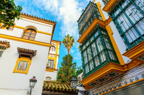 Arquitectura colonial con edificios amarillos y blancos, contraventanas verdes y palmeras en Santa Cruz de la Palma