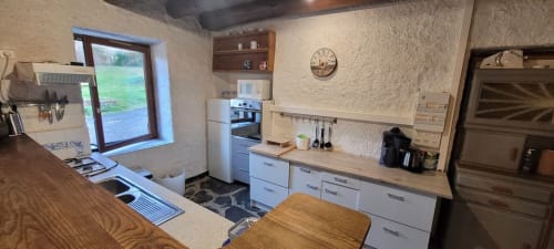 Cuisine de charme à Au Bord de la Dunière avec placards blancs, plan de travail en bois et vue sur la rivière à Sainte-Sigolène