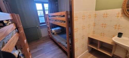 Chambre de gîte à Au Bord de la Dunière avec lits superposés, mobilier en bois et salle d'eau commune à Sainte Sigolène