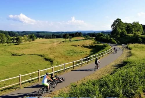Piste cyclable pittoresque au bord de la rivière à la gîte Au Bord de la Dunière à Sainte-Sigolène, France, avec des champs verdoyants