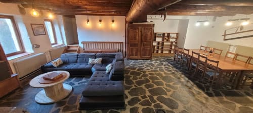 Spacieux salon du cottage Au Bord de la Dunière avec canapé sectionnel bleu, table à manger et mobilier rustique en bois