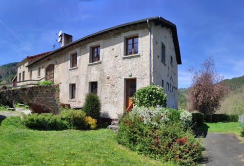 Cottage Au Bord de la Dunière à Sainte Sigolène, façade en pierre, jardin aménagé et vues sur la vallée fluviale