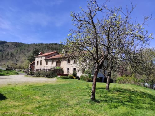 Cottage Au Bord de la Dunière à Sainte Sigolène avec jardin, arbre fleuri et vue sur les collines boisées