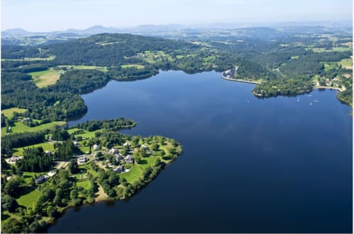 Vue aérienne d'un lac entouré de forêts verdoyantes et de paysages ruraux près de Sainte-Sigolène, France