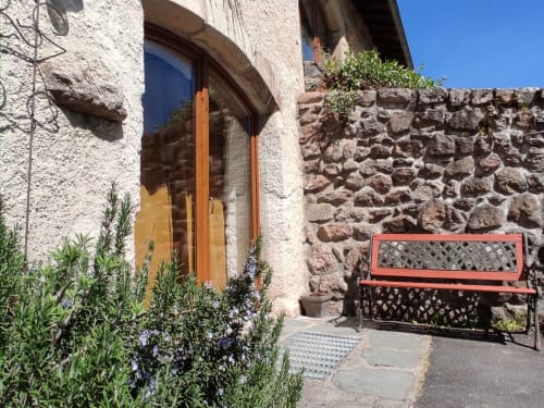 Entrée du gîte Au Bord de la Dunière avec porte en bois, murs en pierre et coin détente à Sainte-Sigolène