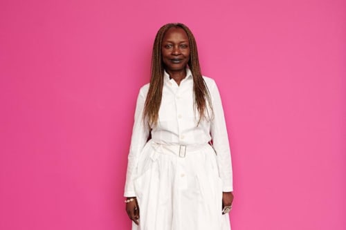 Donna professionista in abito bianco su sfondo rosa, ritratto dello staff del Ca Cortigiane hotel Venezia