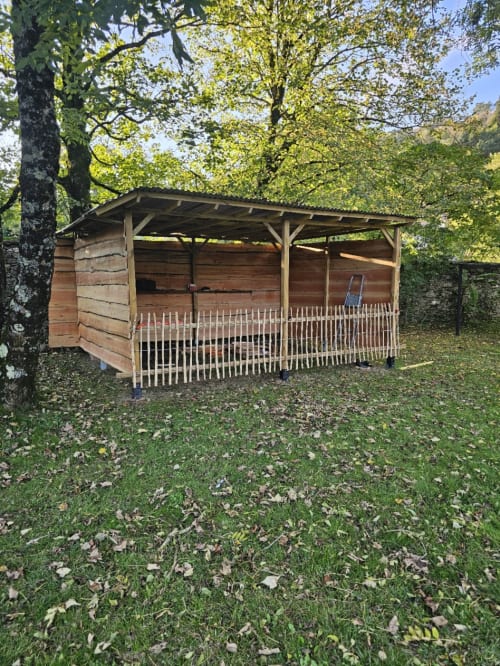 Rustic wooden shelter with white picket fence at Bastide du Thoré, a charming bed and breakfast nestled among trees in