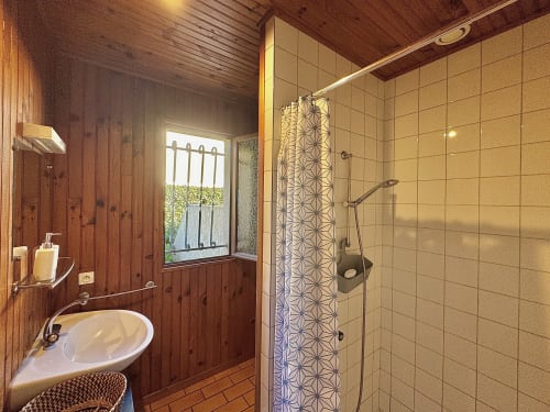 Cette salle d'eau dispose d'un lavabo et de toilettes, offrant un espace  et fonctionnel pour votre confort.