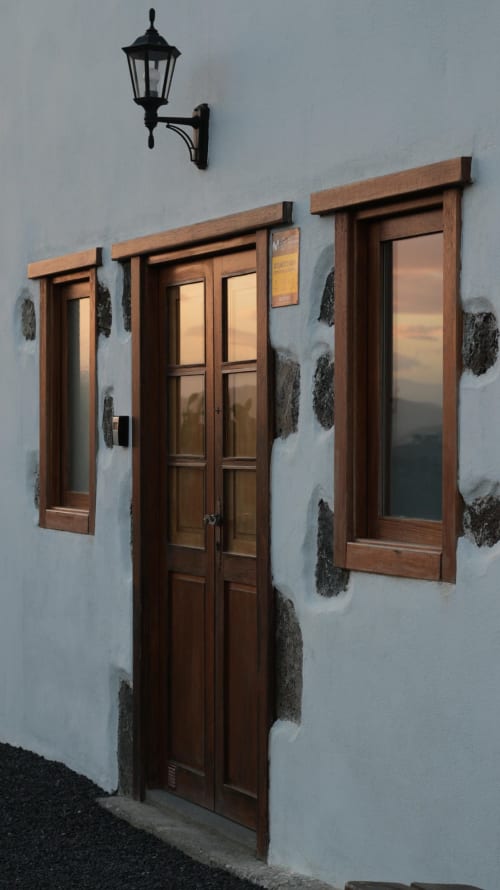 Entrada de Finca de La Geria con puertas de madera, ventanas y aplique de pared tradicional en negro en Yaiza