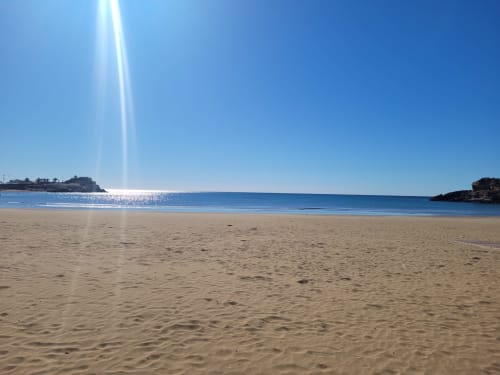 Magnifique plage de sable à Puerto de Mazarrón avec eaux bleues calmes et lumière ensoleillée, vue parfaite depuis les Apartamentos Taravilla
