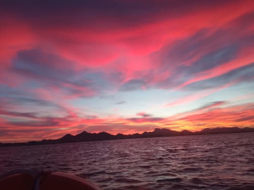 Coucher de soleil spectaculaire sur Puerto de Mazarrón avec ciel doré et silhouettes de montagnes reflétées dans les eaux calmes de la Méditerranée