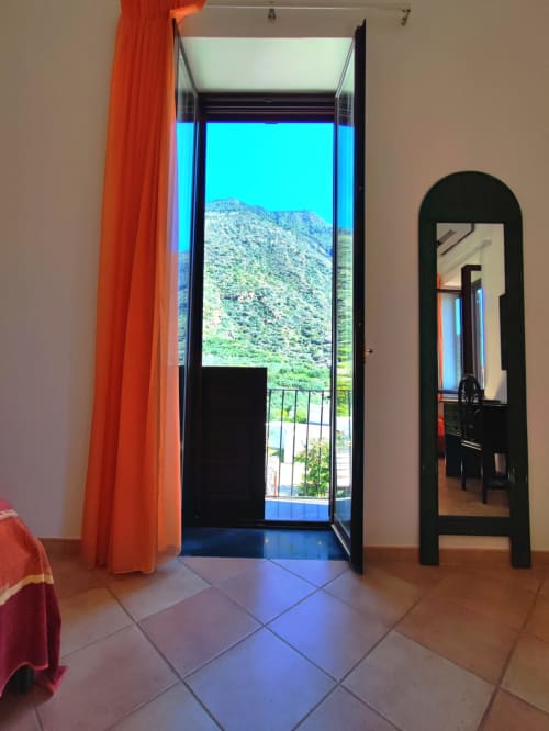 Camera quadrupla con porte aperte sulla vista del paesaggio montano dell'Hotel Principe di Rinella, Rinella Italia
