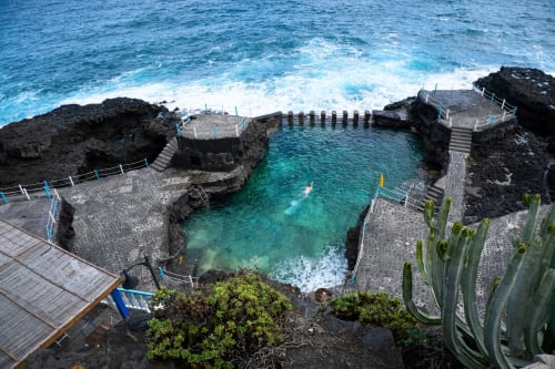 Piscina natural en Apartamentos Rocamar en Santa Cruz de la Palma, aguas turquesas rodeadas de rocas volcánicas y costa