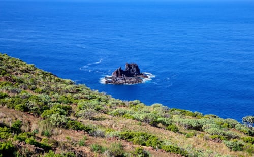 Isla rocosa frente a costa de colina exuberante cerca de Apartamentos Rocamar, Santa Cruz de la Palma