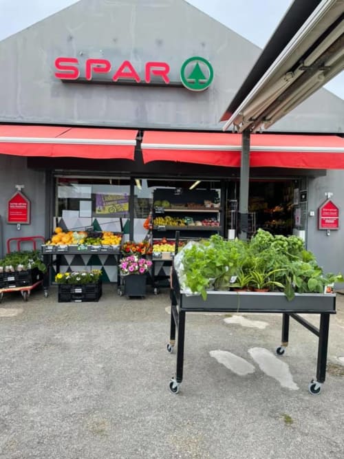 Façade de supermarché SPAR avec étalages de fruits et légumes frais et plantes à l'extérieur, Belle-Île-en-Mer