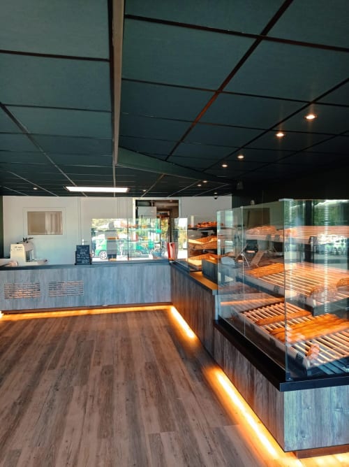 Intérieur moderne de la boulangerie Locations Loc'Maria, Belle Île-en-Mer, avec vitrines de pains frais et pâtisseries.