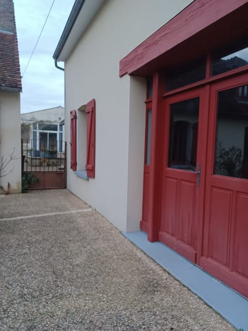 Réception de l'hôtel Accolade à Châteaudun avec portes et volets rouges donnant sur la cour intérieure