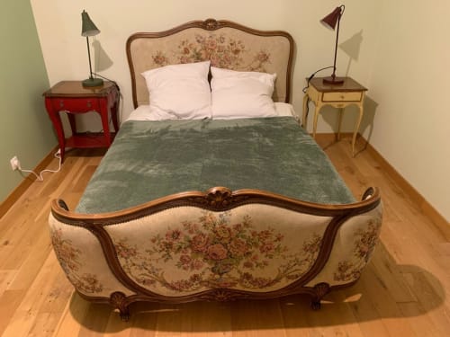 Chambre élégante à l'hôtel Accolade à Châteaudun avec lit fleuri orné, literie verte, tables de nuit assorties avec lampes