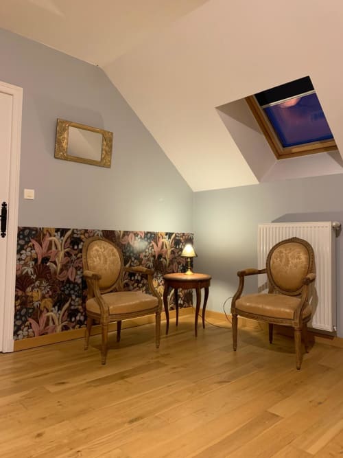 Élégante réception de l'hôtel Accolade avec mobilier d'époque, papier peint floral et verrière à Châteaudun