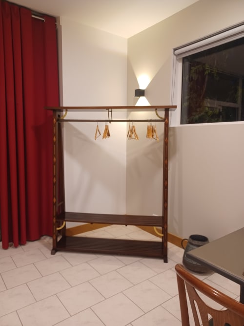 Hall de réception de l'Hôtel Accolade à Châteaudun avec lit à baldaquin en bois, rideaux rouges et vue sur le jardin