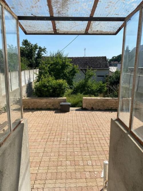 Terrasse de l'appartement Accolade à Châteaudun avec patio en briques, pergola et vue sur la ville