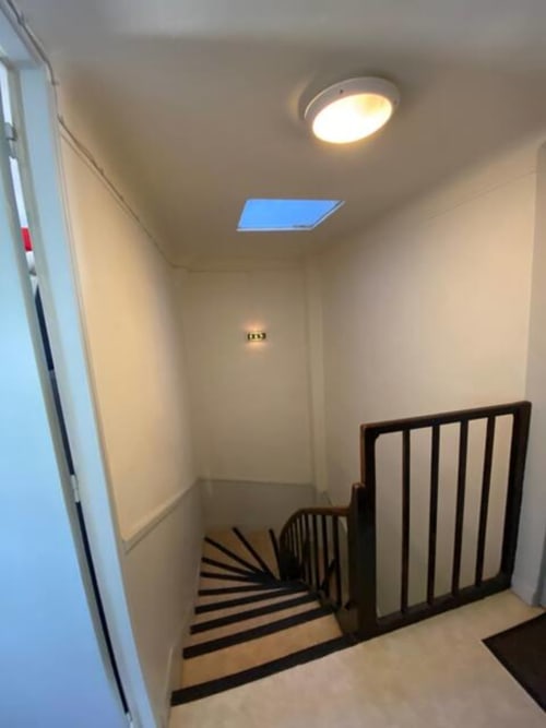 Escalier de l'hôtel Accolade à Châteaudun avec puits de lumière, éclairage moderne et rampe noire