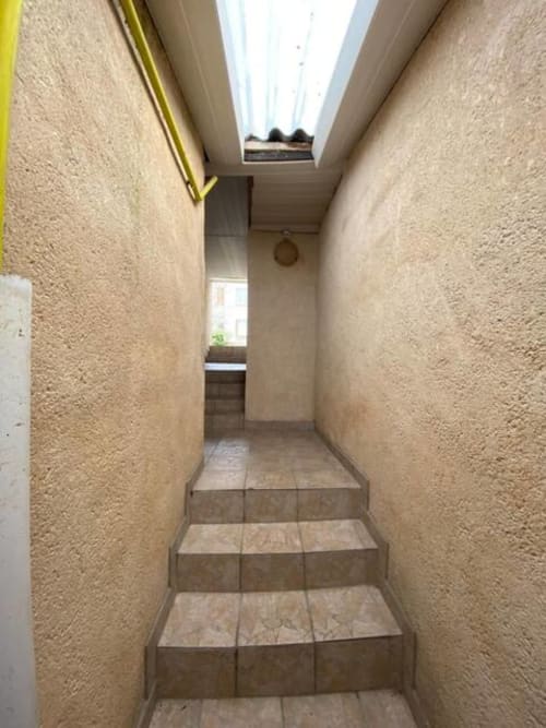 Escalier étroit aux murs texturés et puits de lumière dans l'appartement Accolade, Châteaudun