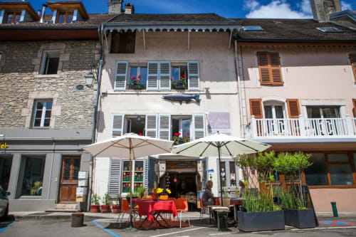 L’Atelier du Peintre | Hébergement | Chambre d’hôtes | Salle à manger extérieure | Plantes | Parasols | Tables et chaises | Ciel | Nuages
