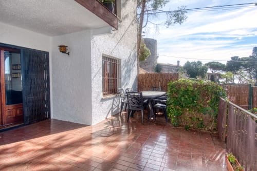 Terrasse de Finques Garcia Enrich à Palafrugell avec table de salle à manger, murs blancs et vue sur la mer