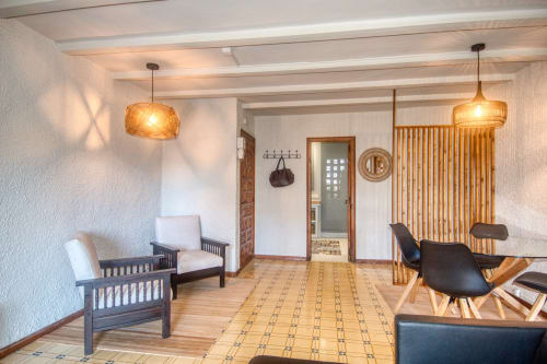Élégant salon de l'hôtel Finques Garcia Enrich à Palafrugell avec poutres en bois, luminaires suspendus et sièges confortables