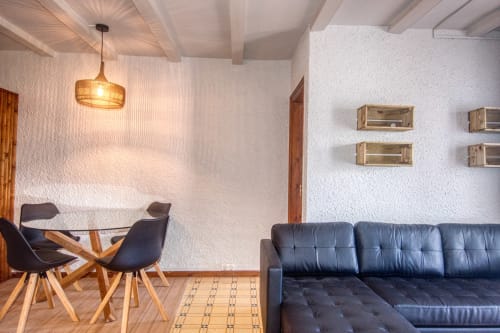 Salon contemporain à Finques Garcia Enrich à Palafrugell avec canapé en cuir bleu, table à manger et éclairage moderne