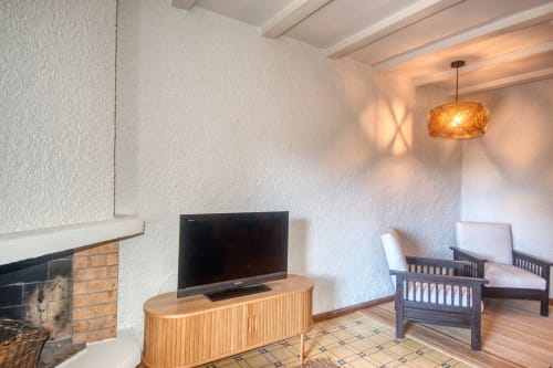 Séjour moderne à l'hôtel Finques Garcia Enrich à Palafrugell avec téléviseur, cheminée, luminaires suspendus et confortable