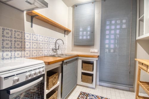 Cuisine moderne avec crédence en carrelage bleu, comptoirs en bois et cuisinière à Finques Garcia Enrich, Palafrugell