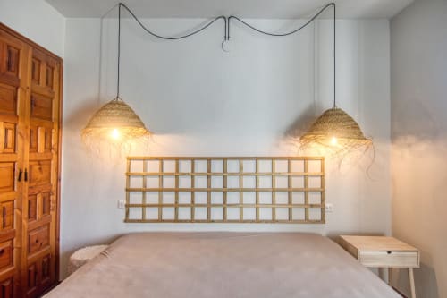 Chambre moderne de l'hôtel Finques Garcia Enrich à Palafrugell avec luminaires en suspension tressés et tête de lit en treillis bois