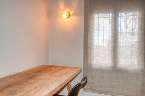 Salle à manger moderne de l'hôtel Finques Garcia Enrich à Palafrugell avec table en bois, applique murale et rideaux voilages