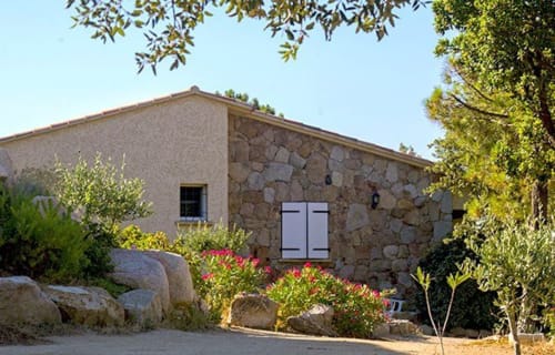 Bâtiment en pierre Vista D'oro avec porte voûtée, fenêtres et jardins méditerranéens à Monacia d'Aullène