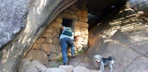 Personne explorant une structure en pierre avec un petit chien à Vista D'oro, Monacia d'Aullène