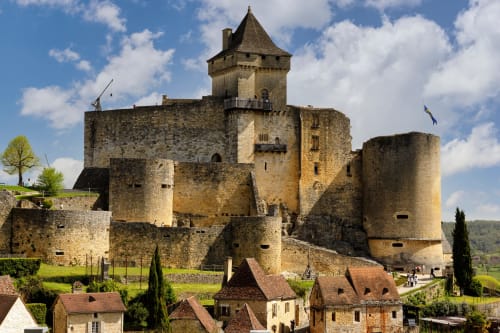Medieval castle with stone towers and conical roof overlooking La Douze, France. Domaine de la Grande Décision hotel