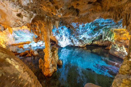 Underground cave with turquoise water and dramatic limestone formations, natural attraction near Domaine de la Grande
