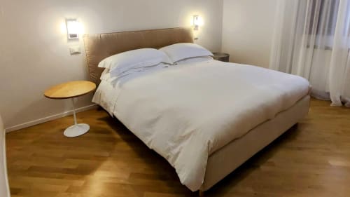 Spacious superior double bedroom at Stella CasaBono hotel in Sulmona with beige upholstered bed, white linens, wooden floors,