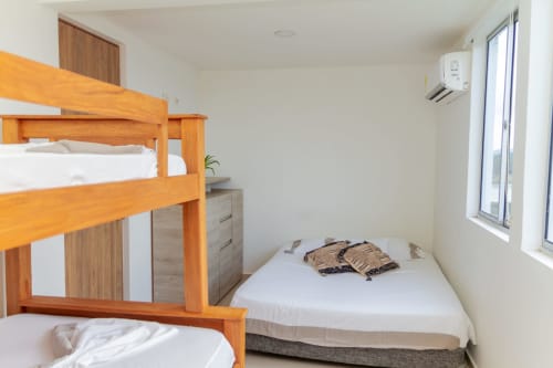 Luminosa habitación en Olamar Living con cama literas de madera, cama individual, aire acondicionado y acceso a balcón en Santiago de Tolú