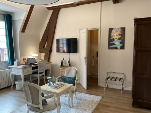 Chambre spacieuse avec coin salon, bureau élégant et poutres, maison d’hôtes à Evry, Essonne, France, charme, confort, ambiance chaleureuse