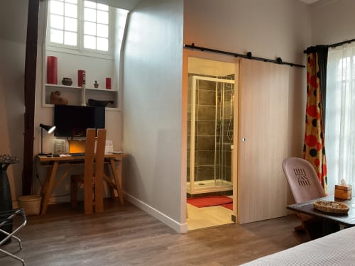 Chambre élégante avec bureau et salle de bain moderne, maison d’hôtes à Evry, France, Essonne, confort premium, atmosphère paisible, accueil chaleureux.