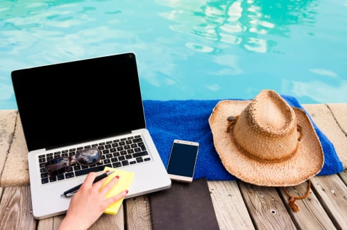Ordinateur portable et smartphone au bord de la piscine à Vista D'oro, Monacia d'Aullène, avec chapeau de paille et serviette