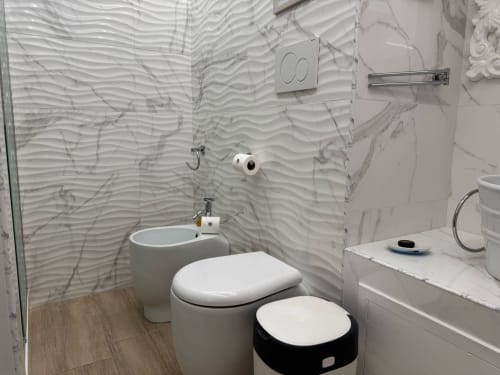 Banheiro moderno do B&B I MORI Catania com azulejos ondulados, fixtures brancos e detalhes em mármore