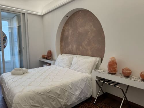 Camera moderna presso B&B I MORI Catania con letto queen, biancheria bianca, testata ad arco marrone caratteristica e lampada di sale dell'Himalaya