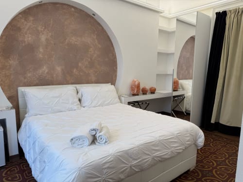 Dormitorio de lujo en la habitación Basileus del B&B I MORI, Catania con cama queen, cabecero curvo, espejo y comodidades modernas