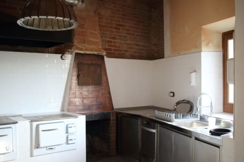 Modern kitchen with exposed brick fireplace at Finques Garcia Enrich hotel in Palafrugell, Spain