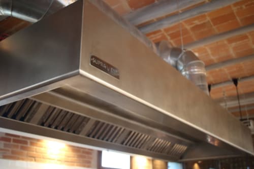 Commercial kitchen exhaust hood with stainless steel ventilation system at Finques Garcia Enrich hotel in Palafrugell