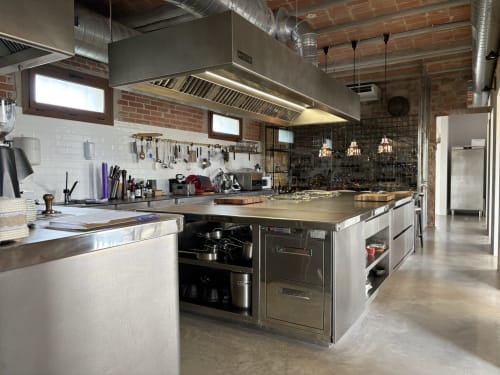 Professional kitchen at Finques Garcia Enrich hotel in Palafrugell with stainless steel counters, industrial appliances, and